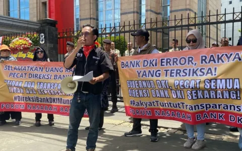 Jakarta – Puluhan nasabah yang tergabung dalam Forum Nasabah Bank DKI menggelar aksi damai di depan Kantor Bank DKI di Jalan Suryopranoto, Jakarta Pusat, Selasa, 14 April 2025. Aksi ini merupakan bentuk kekecewaan nasabah Bank DKI atas kelumpuhan layanan digital Bank DKI yang telah berlangsung sejak akhir Maret 2025. Menurut Koordinasi Aksi, Yudis Apriliansyah, akibat dari gangguan layanan digital itu, ribuan nasabah tidak bisa melakukan transaksi melalui aplikasi JakOne Mobile. Tidak hanya itu, pencairan bantuan sosial seperti Kartu Jakarta Pintar (KJP) pun mengalami keterlambatan. “Bank DKI adalah bank milik publik. Tapi ketika sistemnya lumpuh, nasabah justru ditinggalkan tanpa kejelasan. Kami menuntut tanggung jawab, bukan sekadar klarifikasi,” tegas Yudis. Dalam aksinya, para demonstran menuntut jajaran direksi bank milik Pemerintah Provinsi Jakarta itu untuk mundur karena dianggap gagal menjamin kelancaran layanan nasabah. Mereka juga meminta Pemprov Jakarta untuk segera mengambil tindakan tegas atas kejadian tersebut. "Kita mendesak untuk jajaran Direksi Bank DKI mundur secara terhormat sebagai bentuk pertanggungjawaban kepada masyarakat dan nasabah. Kita juga meminta Pemprov Jakarta sebagai pemegang saham utama untuk segera memgambil tindakan tegas yang lebih komprehensif," terang Yudis. Dalam orasinya, demonstran mendorong dilakukan audit forensik independen terhadap sistem IT beserta infrastruktur Bank DKI. Para demonstran mengancam akan melakukan aksi unjuk rasa dengan jumlah massa yang lebih banyak jika aspirasi mereka tidak didengarkan.