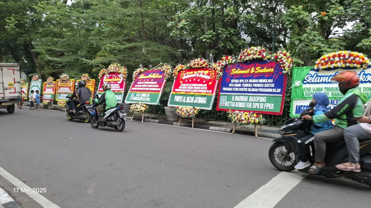 Jakarta — Suasana meriah menyelimuti halaman depan Universitas Nahdlatul Ulama Indonesia (UNUSIA) Jakarta pada Sabtu siang. Ratusan karangan bunga ucapan selamat tampak berjejer rapi, menyambut pelaksanaan Sidang Terbuka Promosi Doktor Kiai Maman Imanulhaq, (17/5). Sidang terbuka ini dijadwalkan berlangsung pukul 14.00 WIB, sebagai bagian dari proses akademik Program Studi Sejarah Peradaban Islam, Fakultas Islam Nusantara UNUSIA. Dalam disertasinya yang berjudul "Dinamika Islam dan Budaya Lokal: Studi Islam Tradisi di Cirebon Abad XVII", Kiai Maman menyoroti peran sentral Cirebon dalam sejarah penyebaran Islam di Nusantara sejak abad ke-15. Penelitiannya menggambarkan bagaimana Islam berkembang bukan hanya sebagai sistem kepercayaan, tetapi juga sebagai kekuatan kultural yang membentuk struktur sosial dan politik masyarakat lokal. Karya ilmiah ini memperkaya khazanah pemikiran Islam Nusantara—sebuah pendekatan keberagamaan yang inklusif, adaptif terhadap budaya lokal, dan berpijak kuat pada sejarah peradaban.